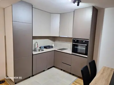 a kitchen with white cabinets and a sink and a stove at Apartman Centrala Lux in Pirot