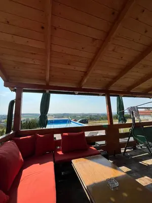 a living room with a couch and a table and a pool at Kuća Pored Sunca in Kruševac