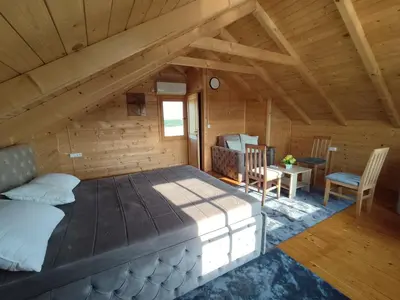 a bedroom in a log cabin with a bed and a desk at Kuća Pored Sunca in Kruševac
