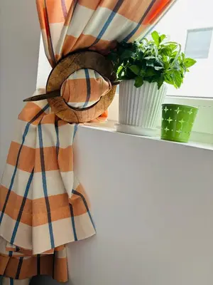 a scarf on a window sill next to a plant at AquaBlue Jagodina in Jagodina