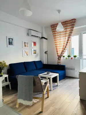 a living room with a blue couch and a table at AquaBlue Jagodina in Jagodina