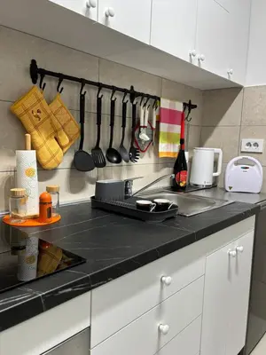 a kitchen with a black counter top with utensils at AquaBlue Jagodina in Jagodina