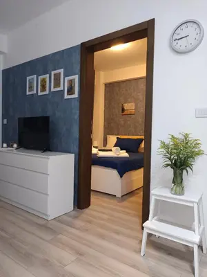 a bedroom with a bed and a clock on the wall at AquaBlue Jagodina in Jagodina