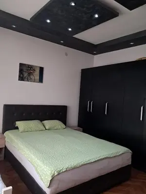 a bedroom with a large bed with black cabinets at Lola Jagodina in Jagodina