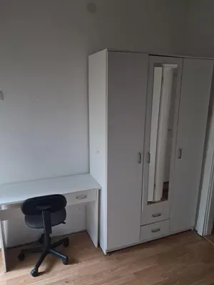 a white desk with a chair next to a cabinet at Lola Jagodina in Jagodina