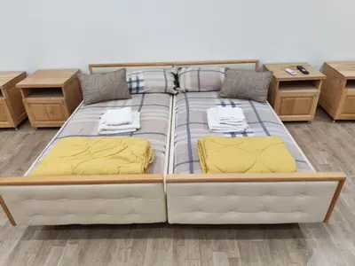 a large bed in a room with two tables at Kej apartman 2 duplex in Paraćin