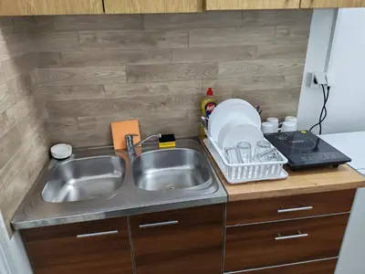 a kitchen counter with a sink and a dish rack at Kej apartman 2 duplex in Paraćin