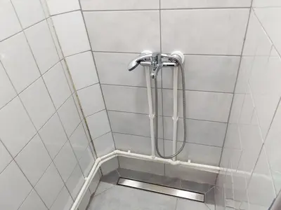 a shower in a white tiled bathroom at Kej apartman 2 duplex in Paraćin