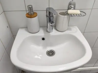 a white sink with two cups on top of it at Kej apartman 2 duplex in Paraćin