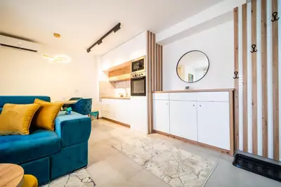 a living room with a blue couch and a mirror at Todorović Lux Vrnjačka Banja in Vrnjačka Banja