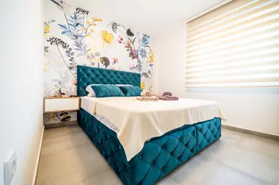 a bedroom with a blue bed with a blue headboard at Todorović Lux Vrnjačka Banja in Vrnjačka Banja