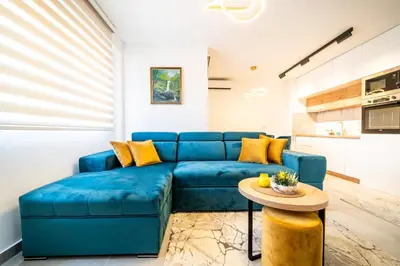 a blue couch in a living room with a table at Todorović Lux Vrnjačka Banja in Vrnjačka Banja