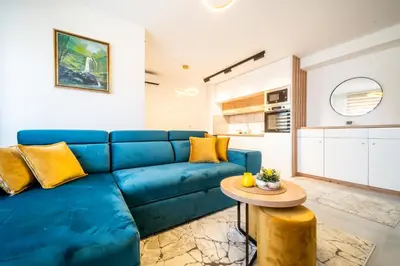 a blue couch in a living room with a table at Todorović Lux Vrnjačka Banja in Vrnjačka Banja