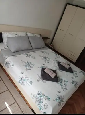 a bed with two towels and two slippers on it at APARTMAN MiG in Vranje