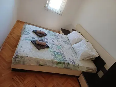 a small bedroom with a bed with two shoes on it at STAN NA DAN MiG -Vranje in Vranje