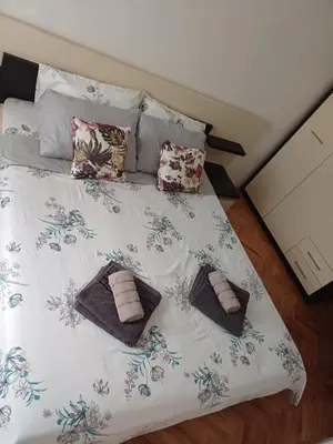 a bed with two towels and pillows on it at STAN NA DAN MiG -Vranje in Vranje