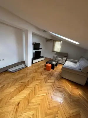 a living room with a couch and a wooden floor at STAN NA DAN MiG -Vranje in Vranje