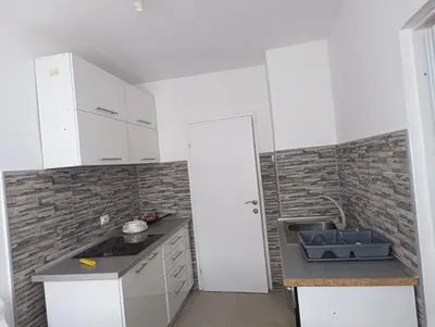 a small kitchen with white cabinets and a sink at Doma Toma, Bela Palanka Town in Bela Palanka