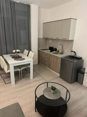 a living room with a table and a kitchen at Apt 2- Sokobanjica apartmani in Soko Banja