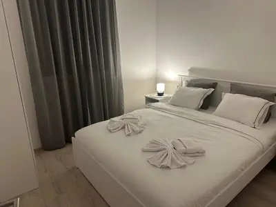 a white bed with white blankets and pillows on it at Apt 2- Sokobanjica apartmani in Soko Banja