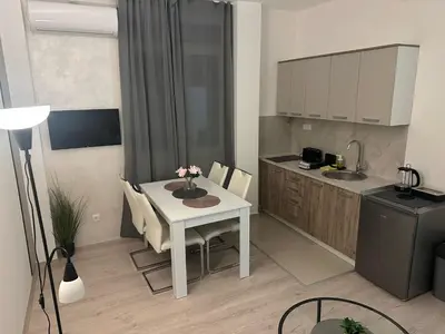 a small kitchen with a white table and a table and chairs at Apt 2- Sokobanjica apartmani in Soko Banja