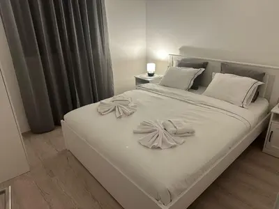 a white bed with white pillows and bows on it at Apt 2- Sokobanjica apartmani in Soko Banja