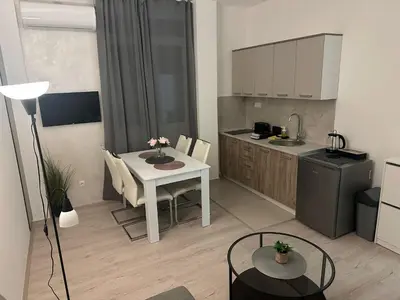 a kitchen with a table and a white table and chairs at Apt 2- Sokobanjica apartmani in Soko Banja