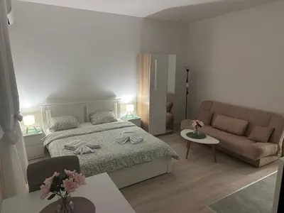 a bedroom with a bed and a couch at Apt 7- Sokobanjica apartmani in Soko Banja