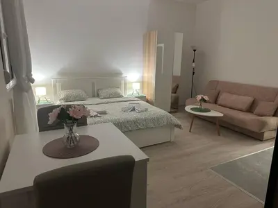 a bedroom with a bed and a living room at Apt 7- Sokobanjica apartmani in Soko Banja