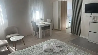 a living room with a small table and a kitchen at Apt 3- Sokobanjica apartmani in Soko Banja