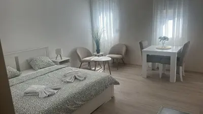 a bedroom with a bed and a table and chairs at Apt 3- Sokobanjica apartmani in Soko Banja