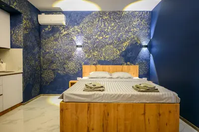 a bedroom with a bed with a blue wall at Tanja Lux in Niš