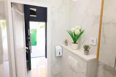 a hallway with white walls and a white counter with plants at Tanja Lux in Niš