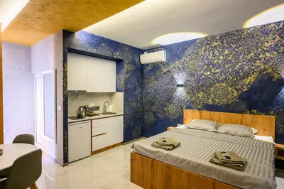 a bedroom with a large bed and a kitchen at Tanja Lux in Niš