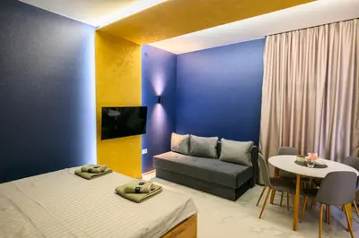 a room with two beds and a table and a couch at Tanja Lux in Niš