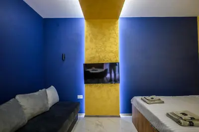 a room with a bed and a blue wall at Tanja Lux in Niš