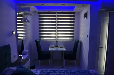 a purple room with a table and chairs and a window at Your Place Studio in Niš