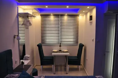 a dining room with a table and chairs and a blue light at Your Place Studio in Niš