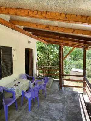 a patio with purple chairs and a table on a porch at Apartmani Radulovic in Kursumlijska Banja