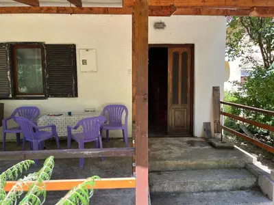a patio with purple chairs and a table and a door at Apartmani Radulovic in Kursumlijska Banja