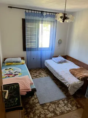 a bedroom with two beds and a window at Apartmani Radulovic in Kursumlijska Banja
