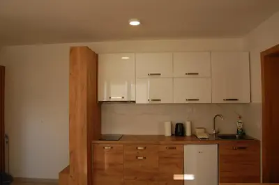 a kitchen with white cabinets and a white refrigerator at Snow Hill Kopaonik in Kopaonik