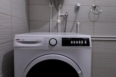 a washing machine in a room with a wall at City Centre Hostel in Niš