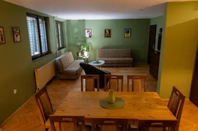a dining room with a table and a living room at City Centre Hostel in Niš