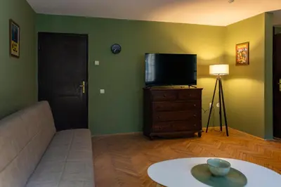 a living room with a couch and a flat screen tv at City Centre Hostel in Niš