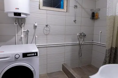 a washing machine in a shower in a bathroom at City Centre Hostel in Niš