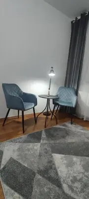 a living room with two chairs and a table at Central apartman3 Novi Sad in Bukorovac