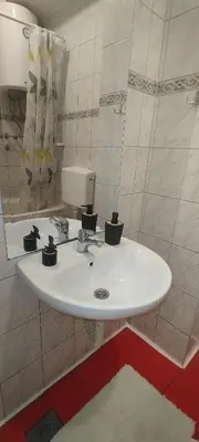 a bathroom with a white sink in a room at Central apartman3 Novi Sad in Bukorovac