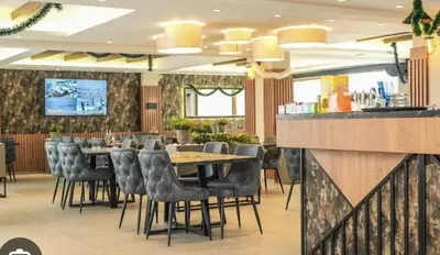 a restaurant with tables and chairs and a bar at Kopaonik-President kop apartment 101 free wellness&spa in Kopaonik