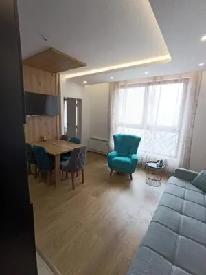 a living room with a table and chairs and a couch at Kopaonik-President kop apartment 101 free wellness&spa in Kopaonik